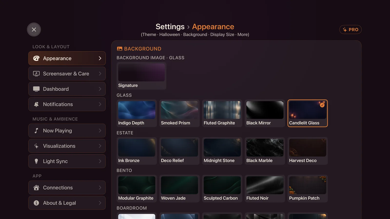 Settings, Appearance, the Background picker, grouped by theme, with the Halloween backgrounds Candlelit Glass, Harvest Deco and Pumpkin Patch among them and Candlelit Glass selected.